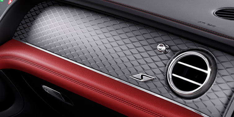 Bentley Valencia Bentley Bentayga S SUV front interior dash withDark Tint Diamond Brushed Aluminium veneer and S badge surrounded by Hotspur red and Beluga black hide