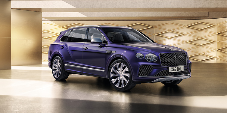 Bentley Valencia Bentley Bentayga Extended Wheelbase Mulliner SUV front three quarter in Tanzanite Purple paint with a gold patterned background