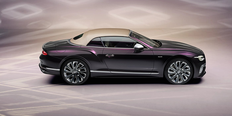 Bentley Valencia Bentley Continental GTC Mulliner convertible in profile with hood up, in Tanzanite Purple paint and 22 inch Mulliner painted and polished wheels