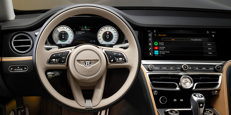 Bentley Valencia Bentley Flying Spur Mulliner sedan front interior detail of steering wheel and driver screens surrounded by Linen and Beluga black hides